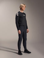 Mannelijk model draagt Alpinestars A-Aria Elite broek in Black Titanium en Aria Polartec Elite LS jersey, zwarte mountainbike performance-kleding, voorzien van lasergewerkte ventilatie en magnetische gespsluiting op de broek, jersey met lange mouwen met witte logo's, complete off-road fietsoutfit