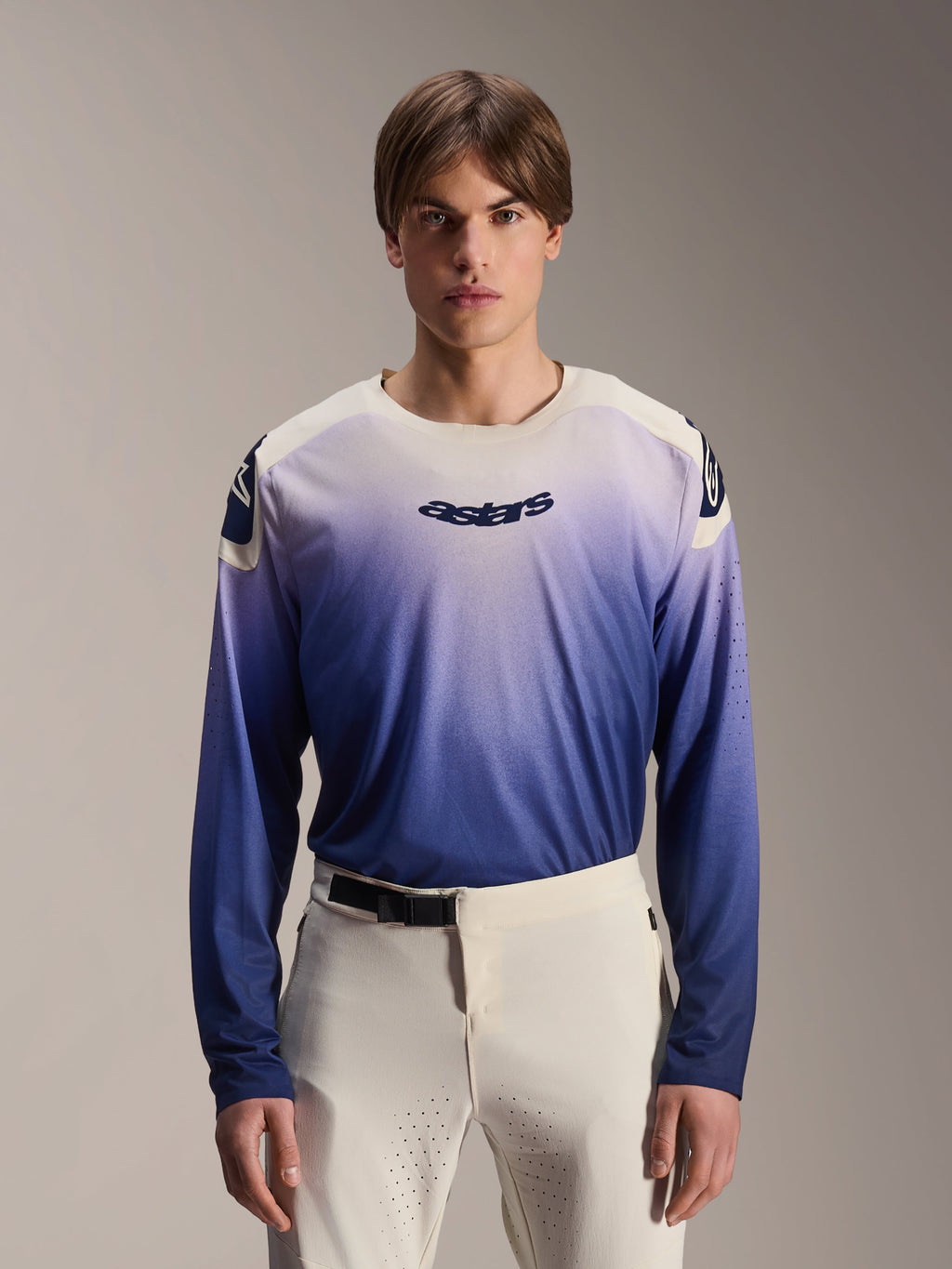 Maillot Alpinestars A-Aria Polartec Maker Elite, maillot de VTT à manches longues, bleu Baja avec dégradé du blanc vers le bleu, porté par un mannequin avec un pantalon blanc, logo bleu foncé sur la poitrine et perforations laser sur les manches, vêtement de performance pour le VTT