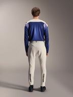 Maillot à manches longues Alpinestars A-Aria Polartec Maker Elite, bleu Baja et blanc cassé, vue arrière d'un mannequin portant un équipement technique de VTT avec un pantalon blanc cassé et le marquage Alpinestars sur le bas des jambes, tenue de cyclisme de performance pour sentiers tout-terrain