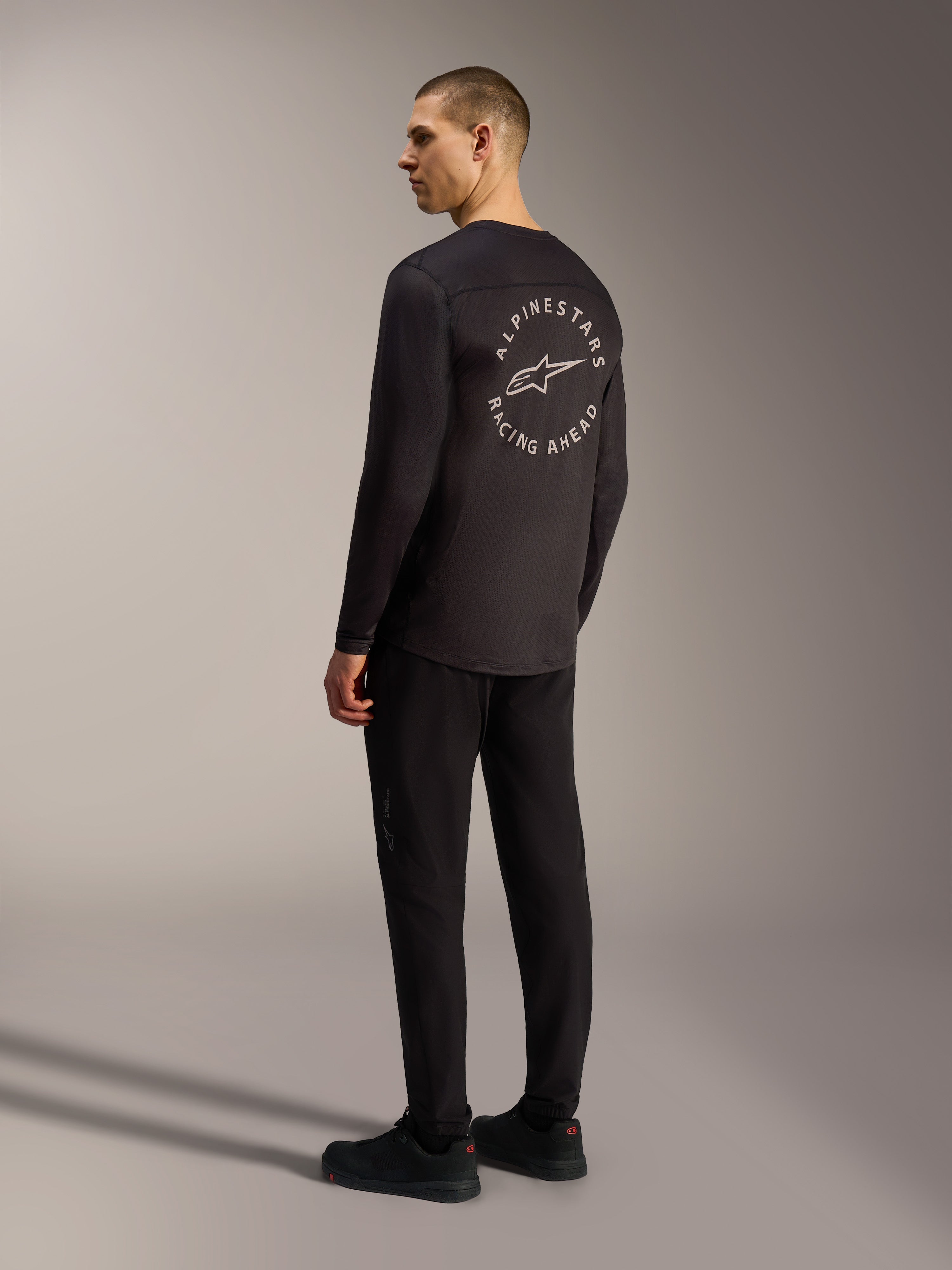Zwart Alpinestars A-Dura Air jersey met lange mouwen, wit cirkelvormig Racing Ahead-logo op de rug, MTB-stijl.