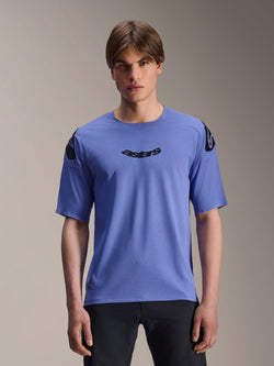 Alpinestars A-Aria Polartec Elite Trikot, Kurzarm-MTB-Trikot, Baja Blue, getragen von einem männlichen Model, mit schwarzem 'astars' Schriftzug auf der Brust und Logo-Details an den Schultern, Performance-Trail-Bekleidung.