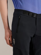 Short Alpinestars A-Aria Elite, short de VTT, Noir Titane, avec fermeture à boucle magnétique, poche zippée et logo Alpinestars blanc, porté avec un maillot de cyclisme bleu, équipement de VTT haute performance