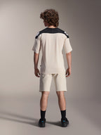 Alpinestars A-Aria Elite Shorts und A-Aria Polartec Elite SS Jersey, Ecru mit schwarzen Schulterpartien, Rückansicht eines Models in Mountainbike-Performance-Ausrüstung, kombiniert mit schwarzen Socken und Schuhen