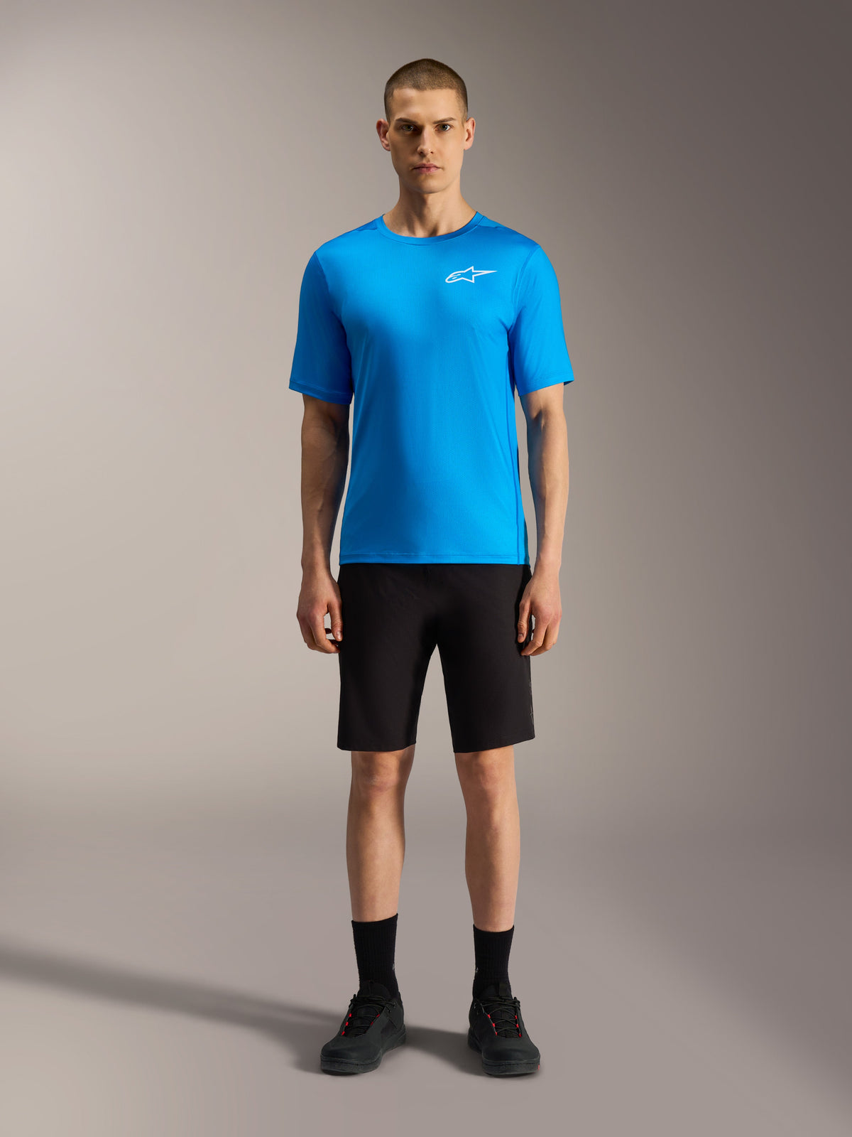 Shorts Alpinestars A-Dura Ride noirs et maillot bleu vif, tenue de VTT haute performance portée par un modèle