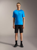 Alpinestars A-Dura Ride Shorts in black and bright blue jersey, performance mountain bike apparel for cycling on a model.