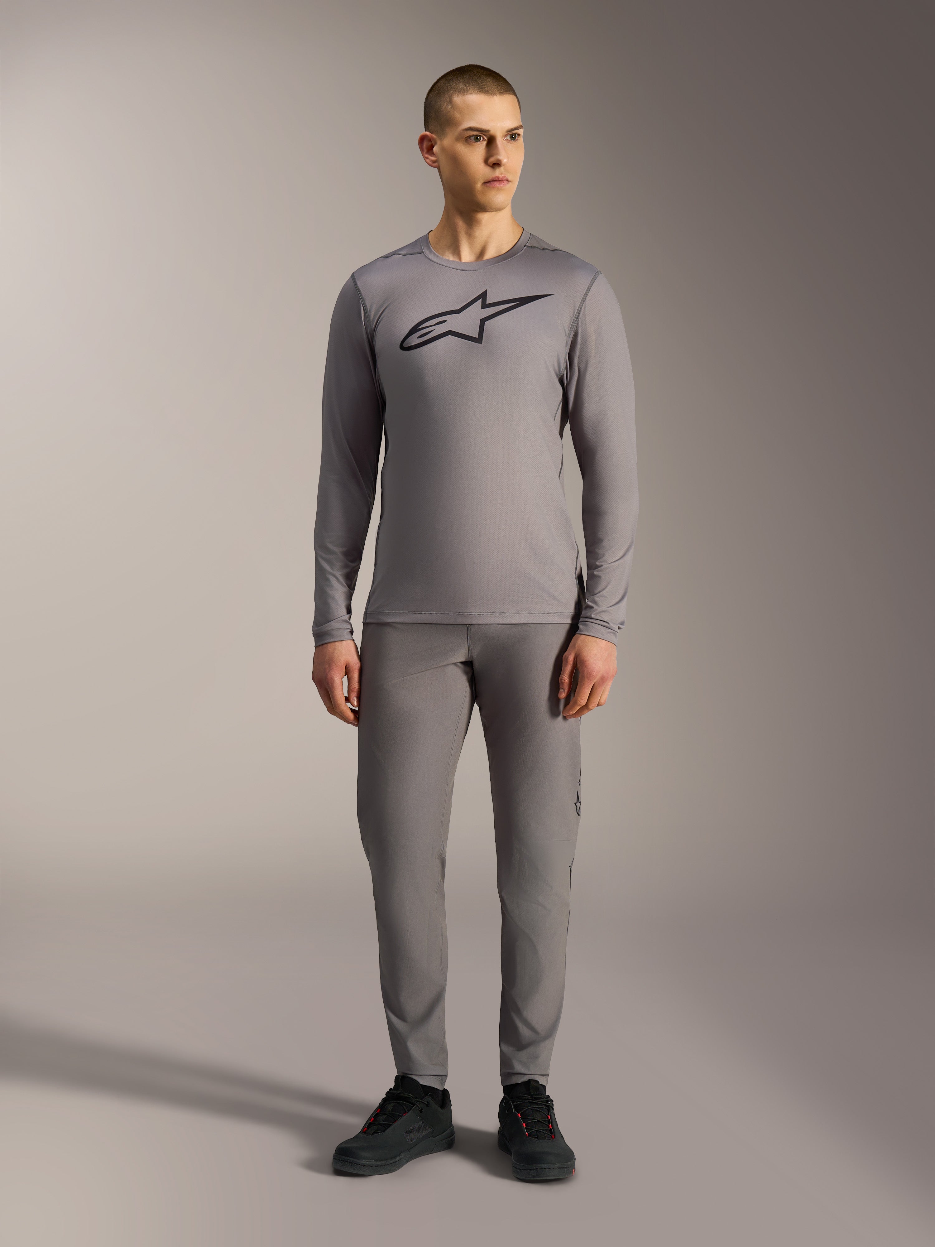 Alpinestars A-Dura Ride Long Sleeve Jersey in Gray, featuring a large black chest logo, worn with matching MTB pants.
