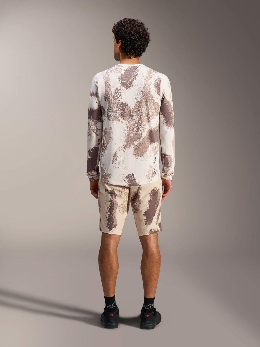 Alpinestars A-Dura Ride LS jersey en shorts in sand camo, complete MTB-outfit, achteraanzicht.