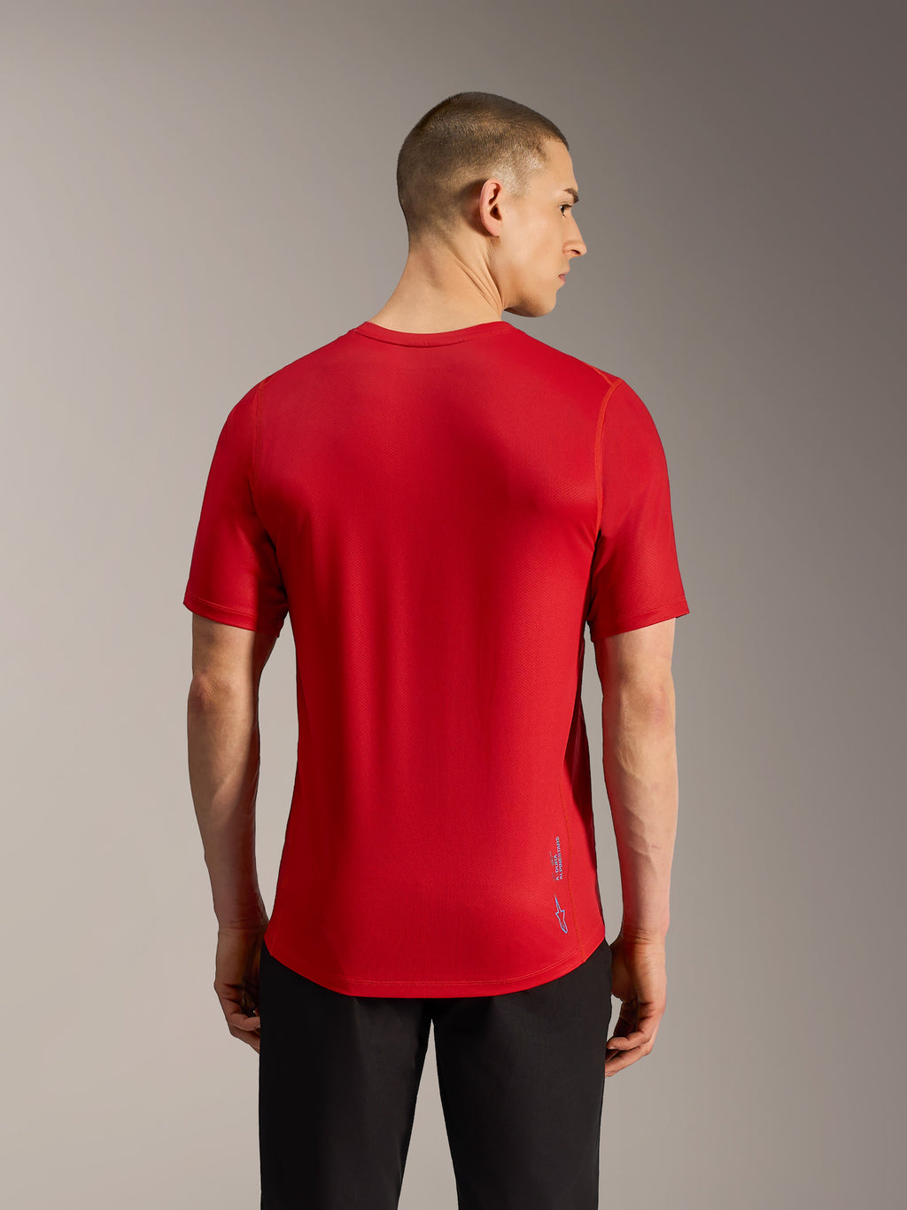 Maillot VTT A-Dura Ride rouge, vue de dos avec tissu jacquard, ourlet arrière allongé et marquage logo discret.