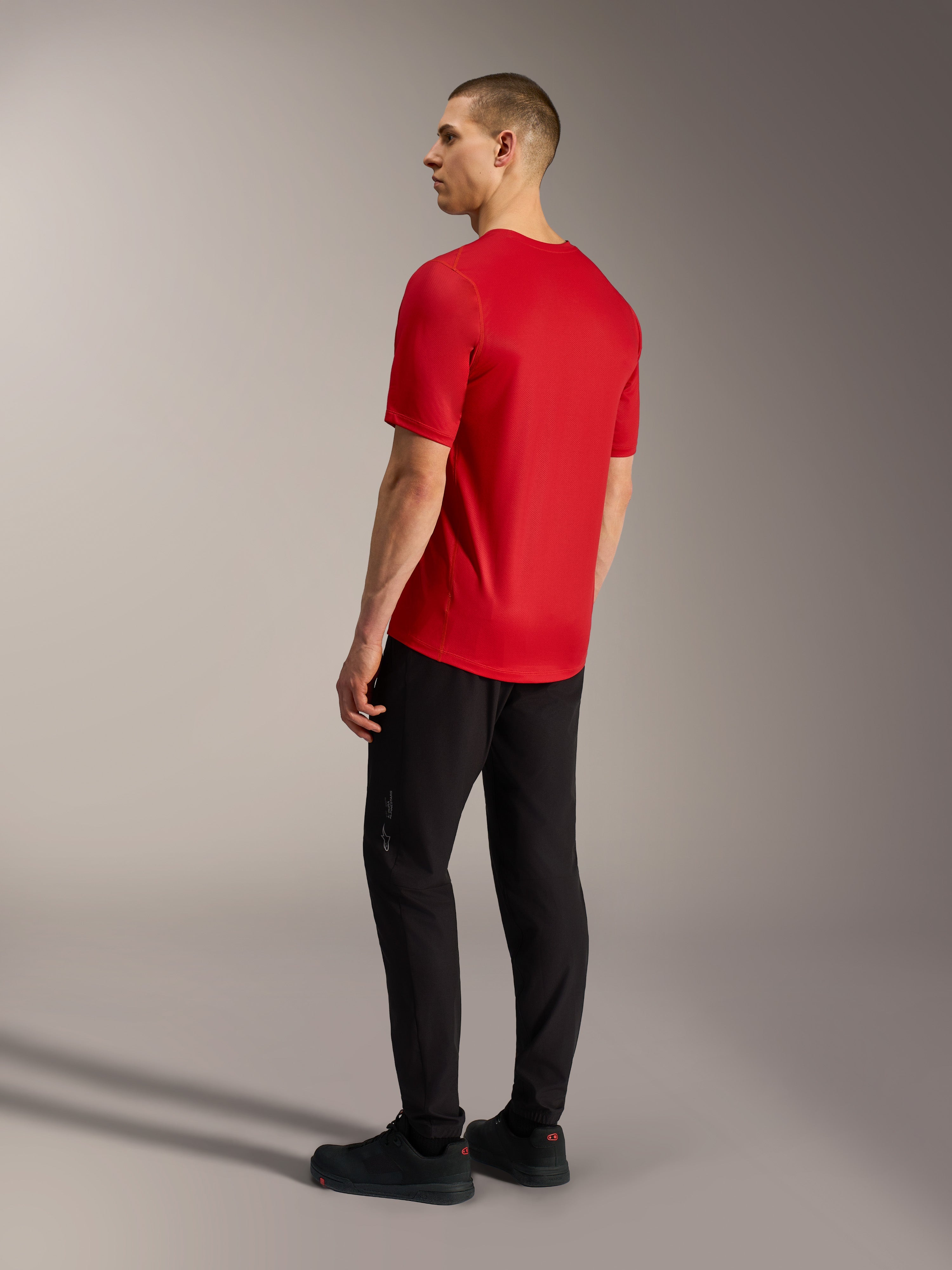 Maillot A-Dura Ride rouge à manches courtes, vue de dos montrant l'ourlet arrière allongé et le tissu stretch VTT.