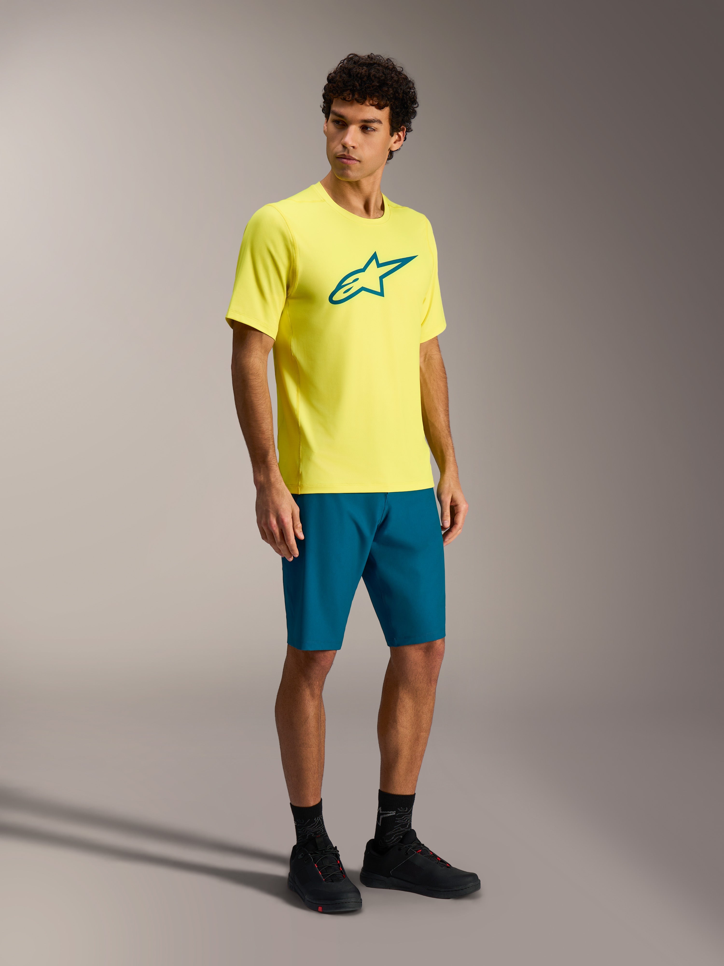 Maillot Alpinestars A-Dura Ride jaune fluo à manches courtes, logo sarcelle, conçu pour la performance en VTT trail.