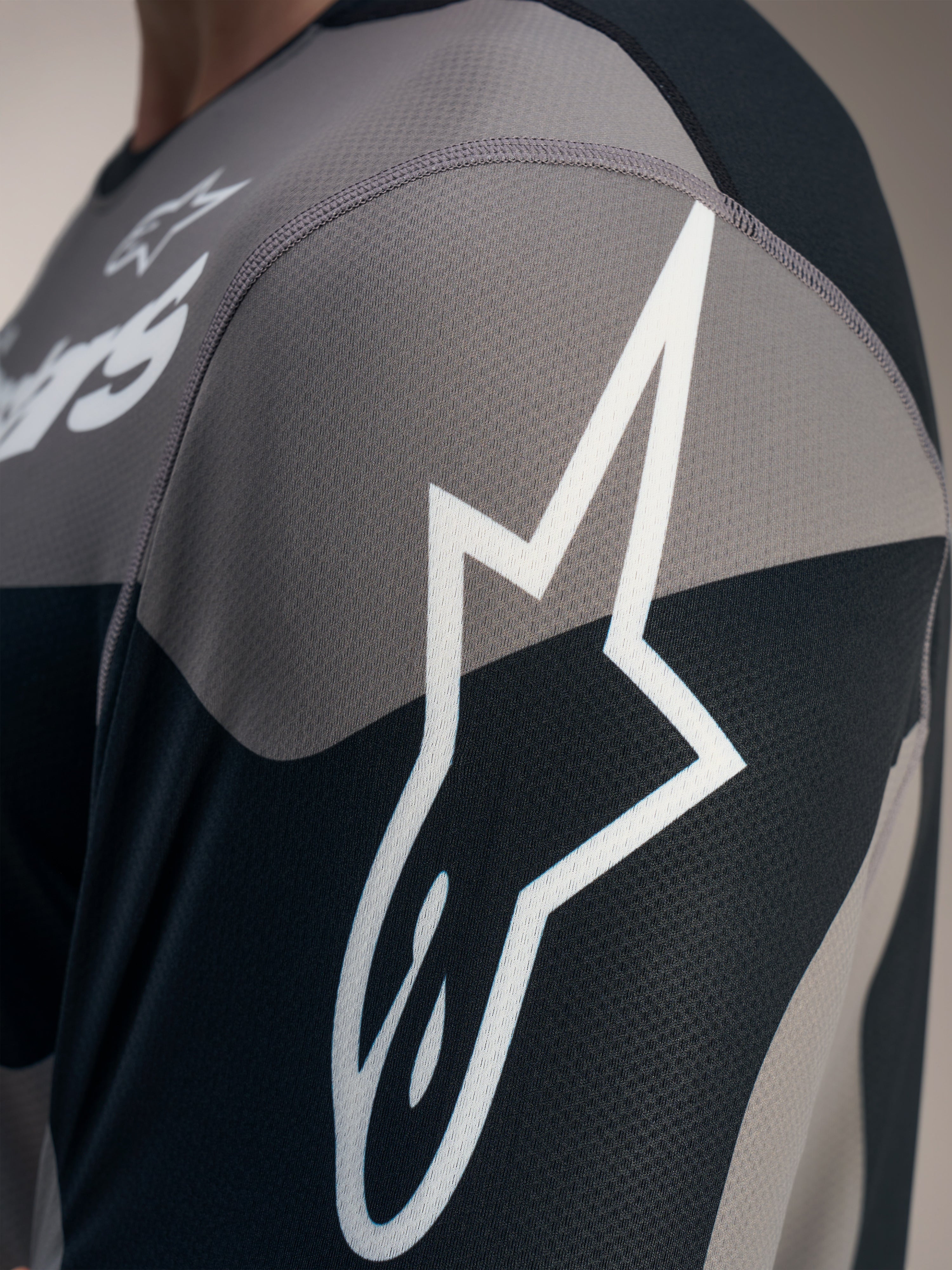 Grijze A-Dura Race Jersey met lange mouwen, wit Astars-logo op getextureerde technische jacquard mesh.