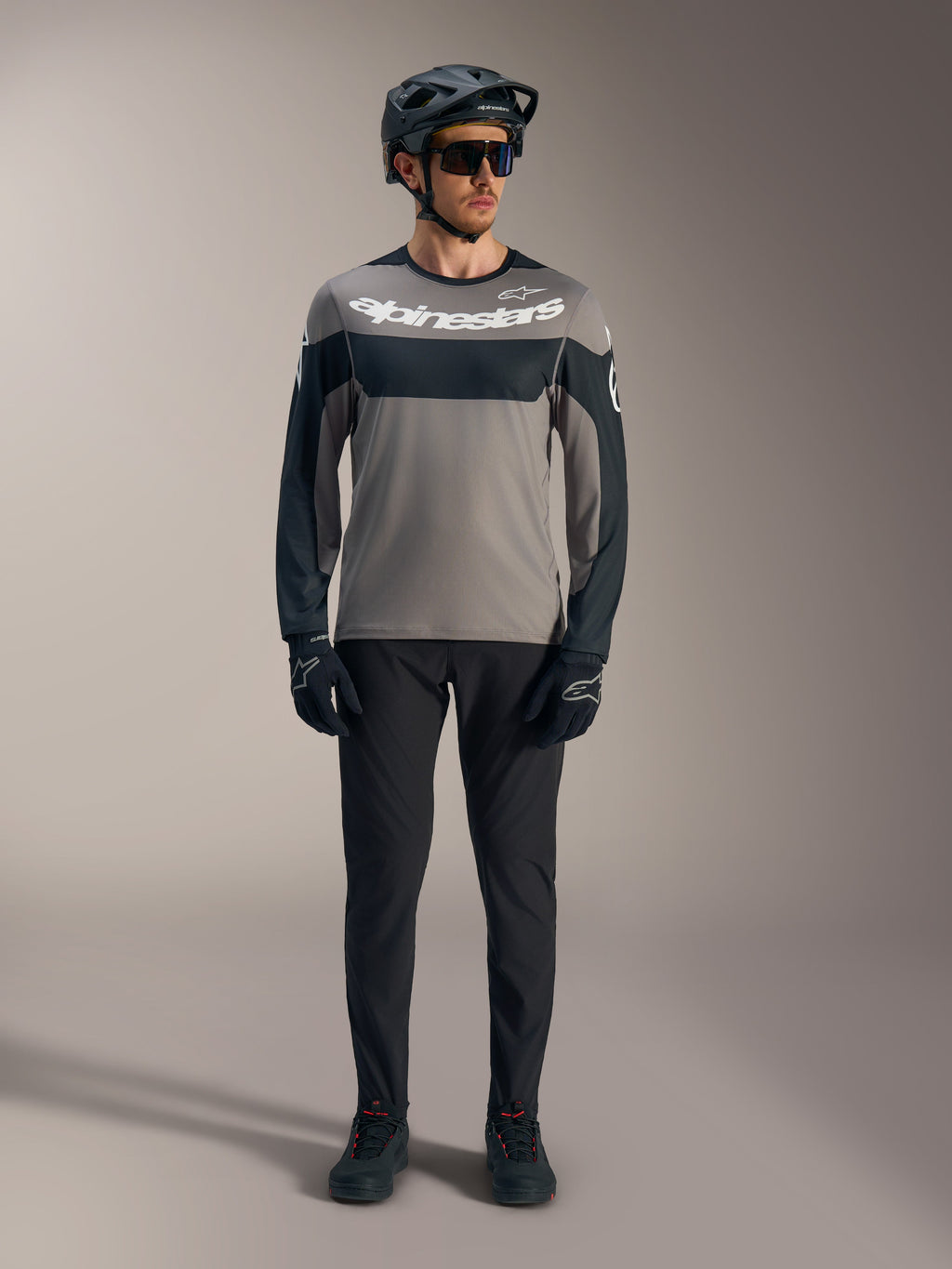 A-Dura Race jersey met lange mouwen in grijs en zwart met wit Alpinestars-logo, gestyled met MTB-uitrusting.