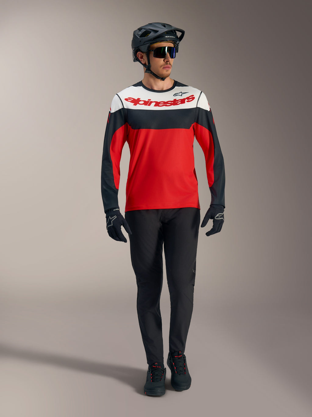 Rode Alpinestars A-Dura Race Jersey met lange mouwen, witte en zwarte panelen, MTB-broek en beschermende uitrusting.