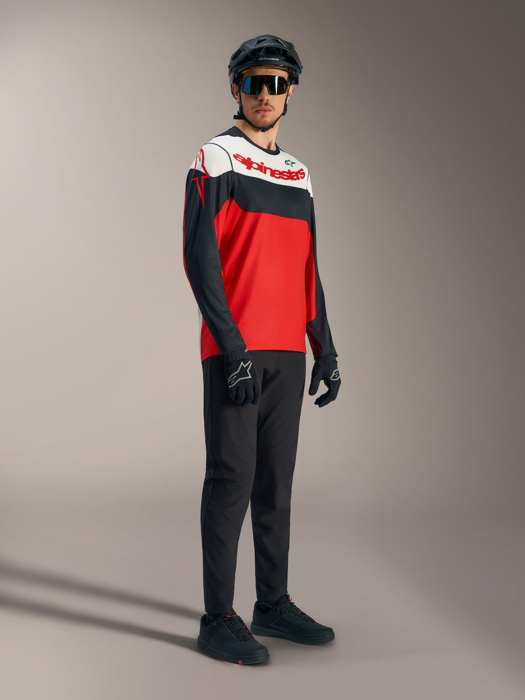 A-Dura Race Jersey met lange mouwen in rood, zwart en wit met logo's, gecombineerd met mountainbike-uitrusting.