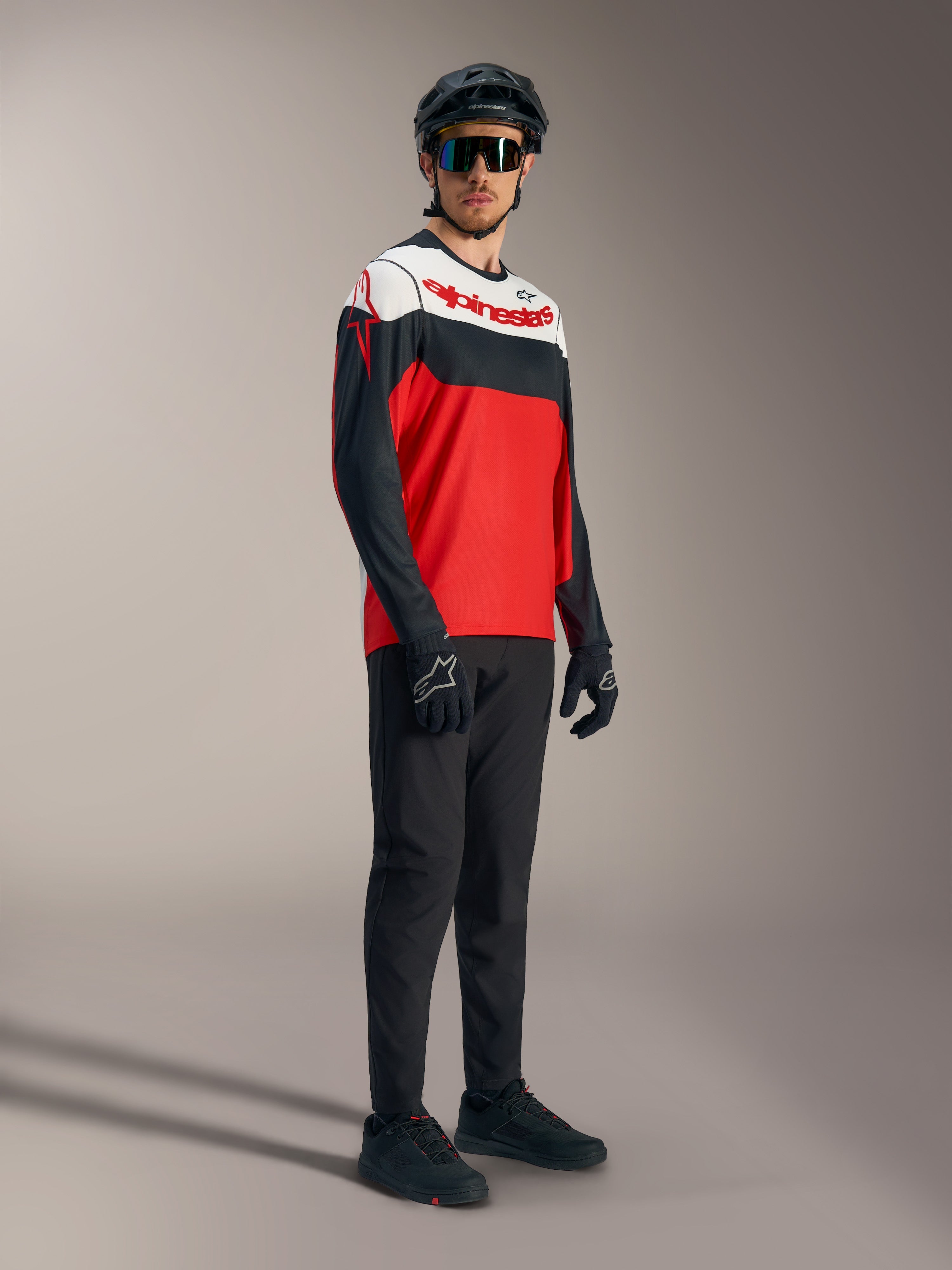 A-Dura Race Jersey met lange mouwen in rood, zwart en wit met logo's, gecombineerd met mountainbike-uitrusting.