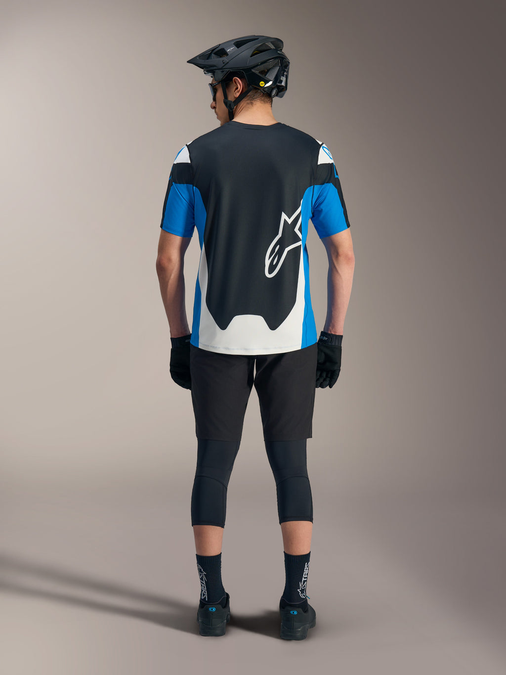 Alpinestars A-Dura Race SS Jersey in blauw en zwart, gestyled met technische MTB-shorts en performance-uitrusting.
