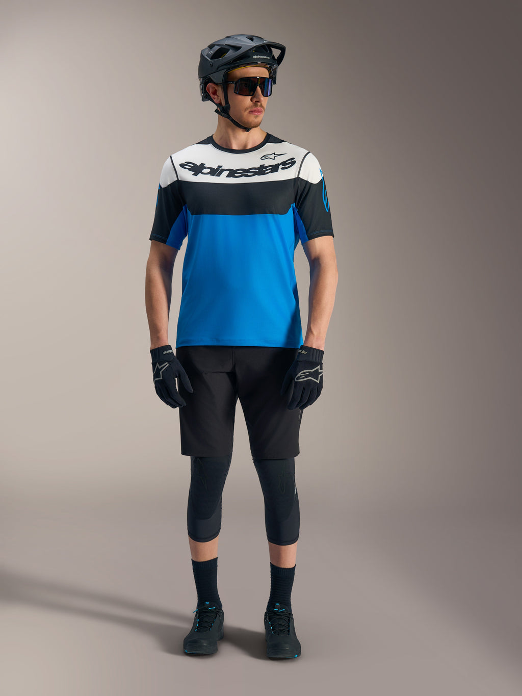 Alpinestars A-Dura Race jersey en shorts, blauw-zwarte mountainbike-gear met helm en kniebeschermers.
