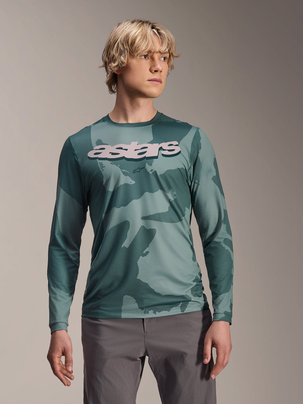 Alpinestars A-Dura Hollow Camo Langarmtrikot, MTB-Jersey, Silver Pine Camo grünes Tarnmuster, großes hellgraues astars-Logo auf der Brust, kombiniert mit grauer Hose, leistungsstarke Mountainbike-Bekleidung