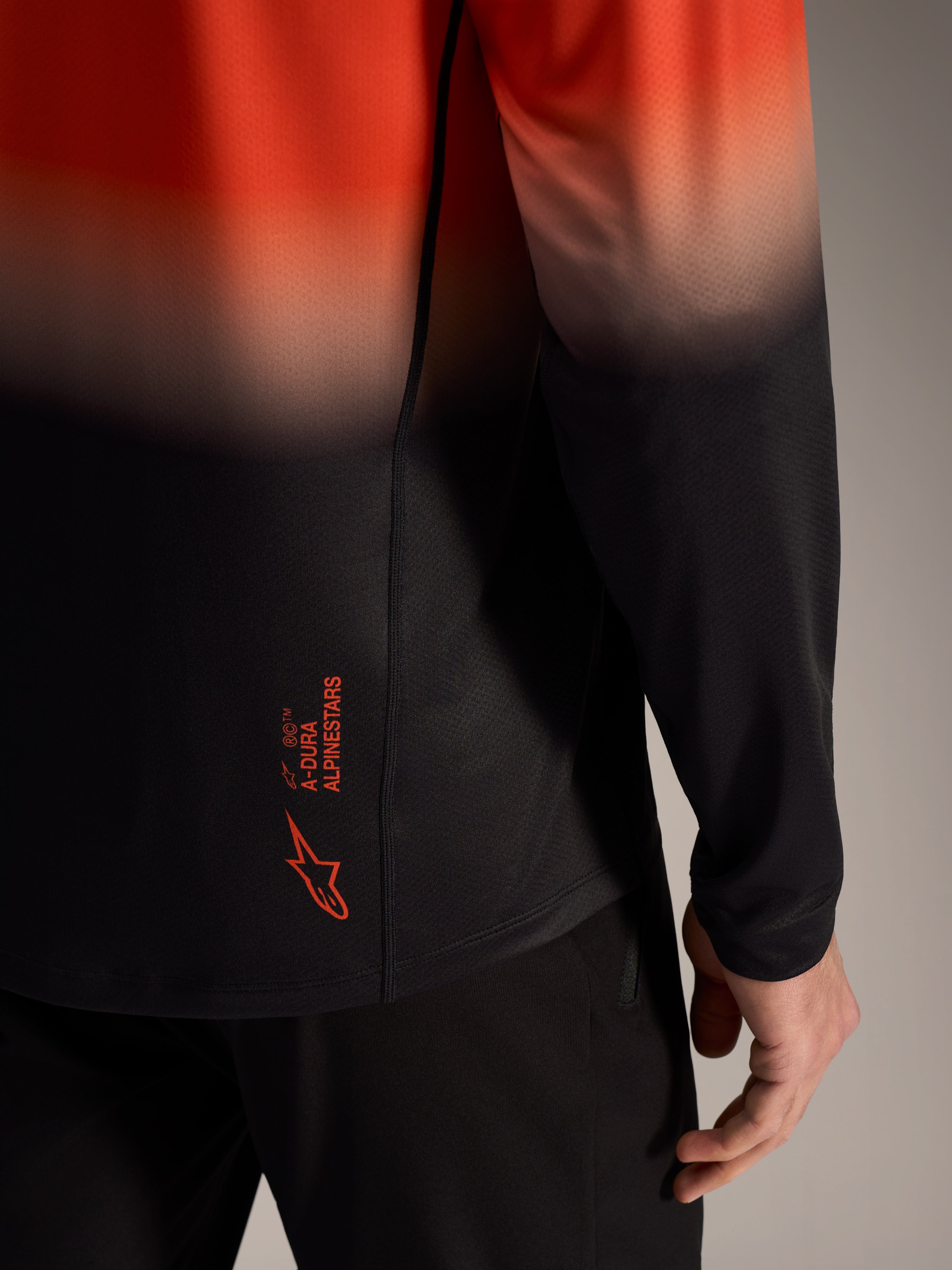 A-Dura ASTARS Jersey 2.0 met oranje-zwart kleurverloop, logo op de onderrug en ademende jacquardstof.