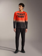 A-Dura ASTARS Jersey 2.0 met lange mouwen, oranje en zwart kleurverloop, groot borstlogo en zwarte MTB-broek.