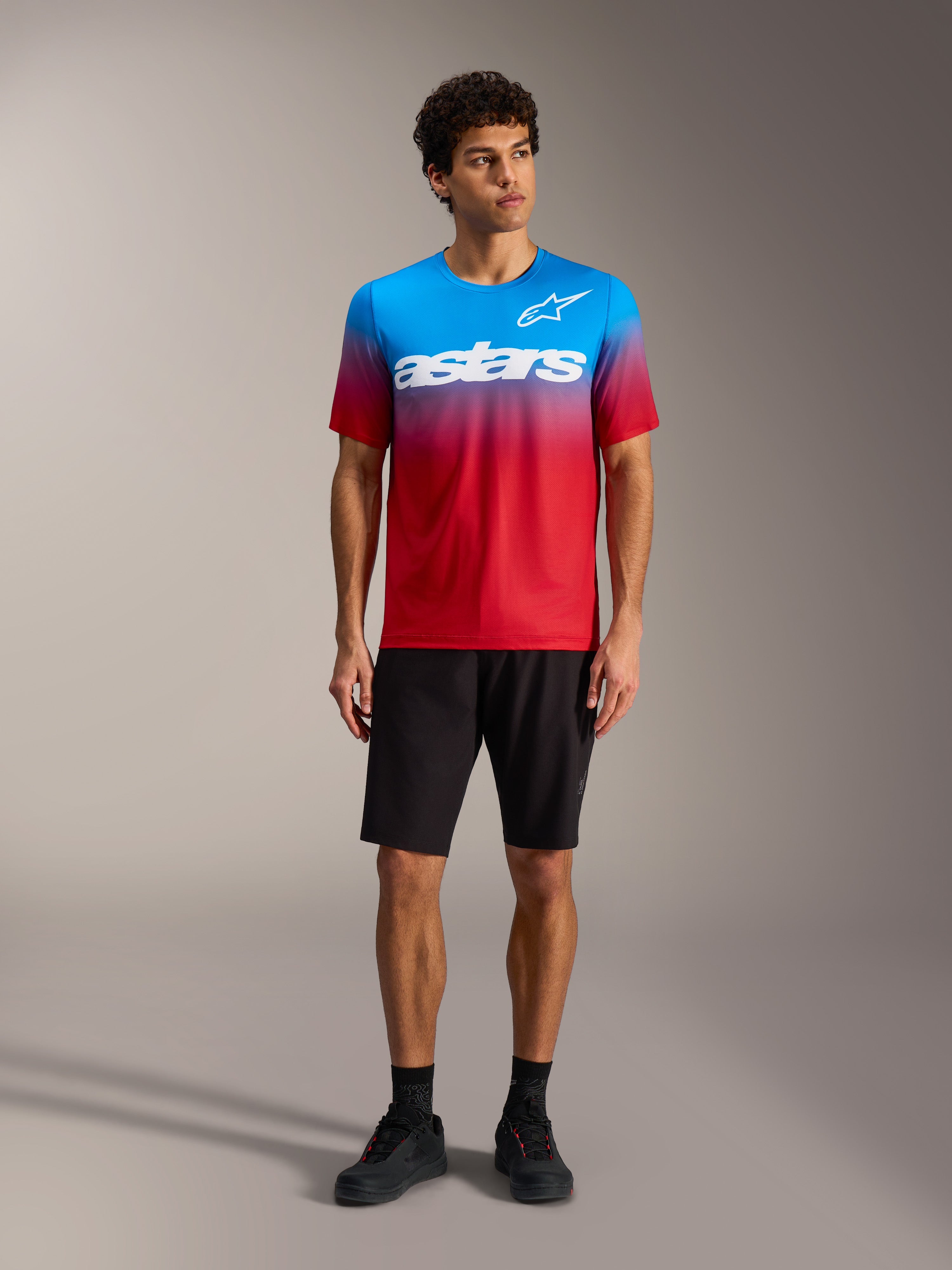 A-Dura ASTARS Jersey 2.0 in Bright Red Blue gradient with white chest logo, paired with black MTB shorts and shoes.