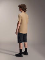 Maillot à manches courtes Alpinestars A-Dura Astar, marron clair, porté avec un short noir et des chaussettes noires, tissu jacquard évacuant l'humidité, vêtement de performance décontracté pour le VTT