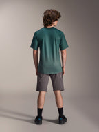 Alpinestars A-Dura Rise Jersey - Short Sleeve, Silver Pine groen, achteraanzicht van een mannelijk model met een grijze korte broek en zwarte sokken, voorzien van een verlengde achterkant en regular fit voor mountainbiken
