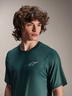 Alpinestars A-Dura Rise Jersey met korte mouwen, Silver Pine groen, klein wit Astars-logo op de borst, ademende jacquard performance-stof, casual mountainbike-kleding, gedragen door een model