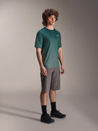 Alpinestars A-Dura Rise Jersey - Korte Mouwen in Silver Pine, groene mountainbike jersey gedragen door een model met grijze short en zwarte sneakers, casual MTB trail kleding met een klein wit logo op de borst