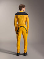 Alpinestars Limited Edition A-Supra Melt Gold Jersey, maillot de VTT à manches longues, jaune foncé, vue de dos, avec empiècements noirs aux épaules, porté avec un pantalon jaune assorti avec un large logo noir à l'arrière, équipement de cyclisme haute performance