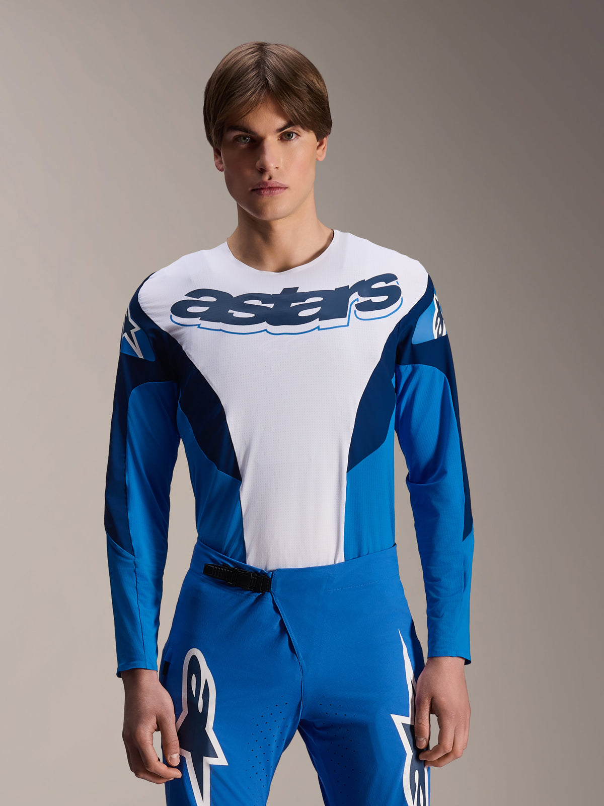 Alpinestars A-Supra Melt Langarm-Trikot, blaues und weißes MTB-Trikot, auffälliges Astars-Branding auf der Brust, dunkelblaue Ärmel, kombiniert mit passender blauer Rennhose mit weißen Stern-Logos, Performance-Mountainbike-Bekleidung
