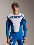 Maillot à manches longues Alpinestars A-Supra Melt, maillot de VTT bleu et blanc, logo astars imposant sur la poitrine, manches bleu foncé, porté avec un pantalon de course bleu assorti avec logos étoiles blancs, équipement de VTT haute performance