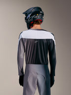 Maillot A-Supra Elite Alpinestars gris dégradé, vue arrière avec empiècement blanc, tissu micro-perforé et logo ASTARS.