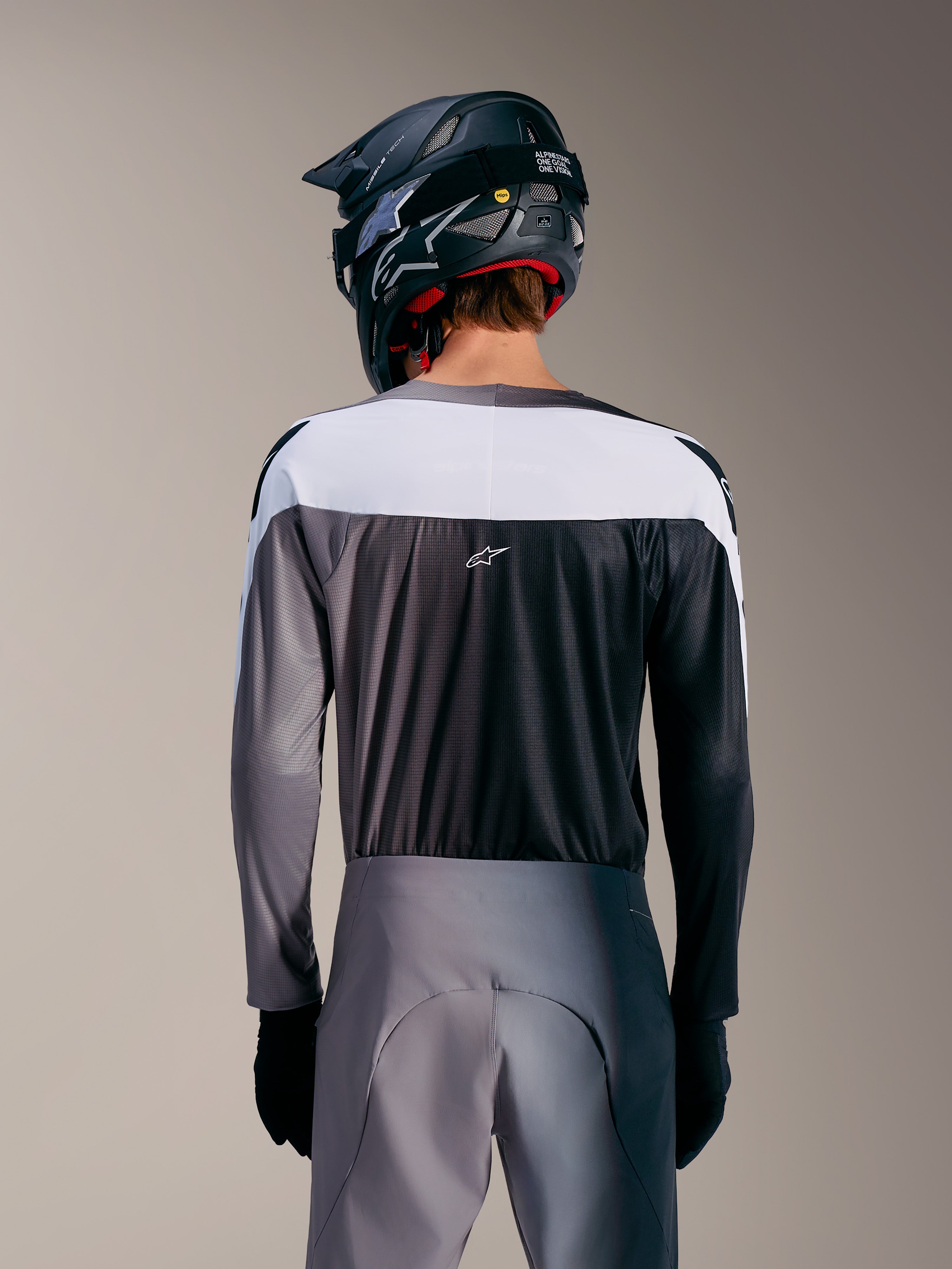 Maillot A-Supra Elite Alpinestars gris dégradé, vue arrière avec empiècement blanc, tissu micro-perforé et logo ASTARS.