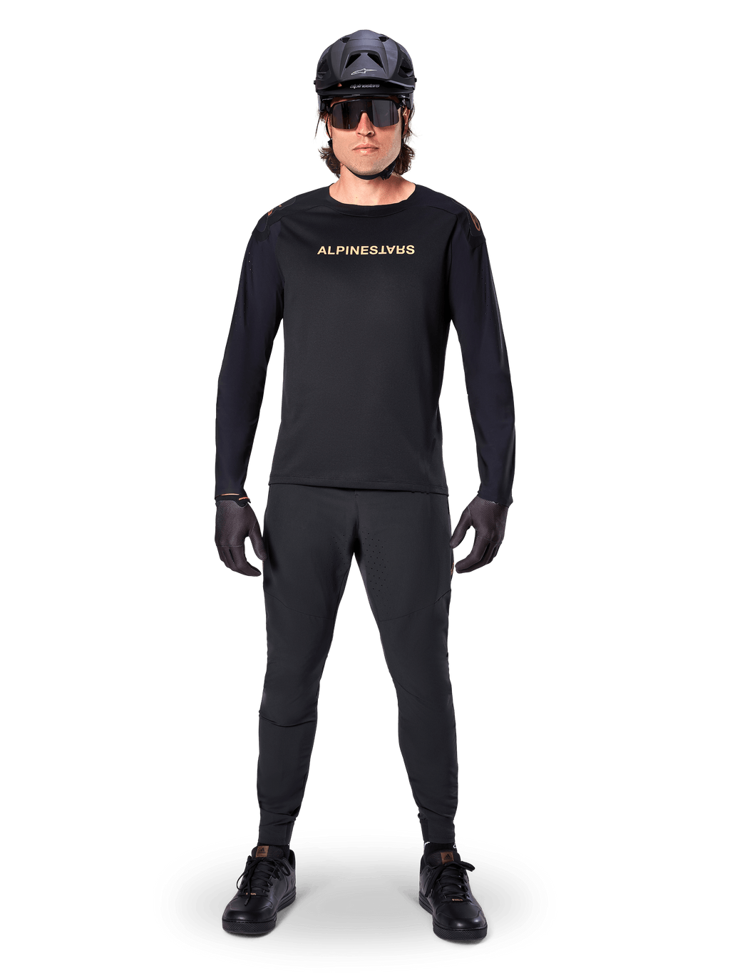 Alpinestars A-Aria Polartec Switch Long Sleeve Jersey, Black, worn by a rider with matching black technical pants, black helmet, sunglasses, and black gloves, performance MTB gear for off-road trails