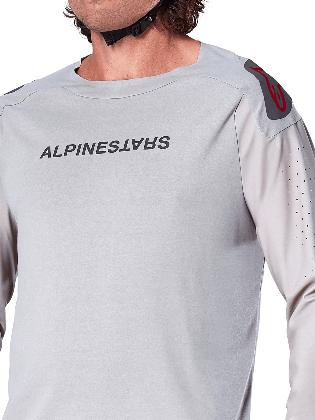 Gros plan sur le maillot à manches longues Alpinestars A-Aria Polartec Switch en gris clair, avec logo Alpinestars sur la poitrine, logo rouge sur l'épaule et manches perforées au laser pour la circulation de l'air, équipement de VTT haut de gamme