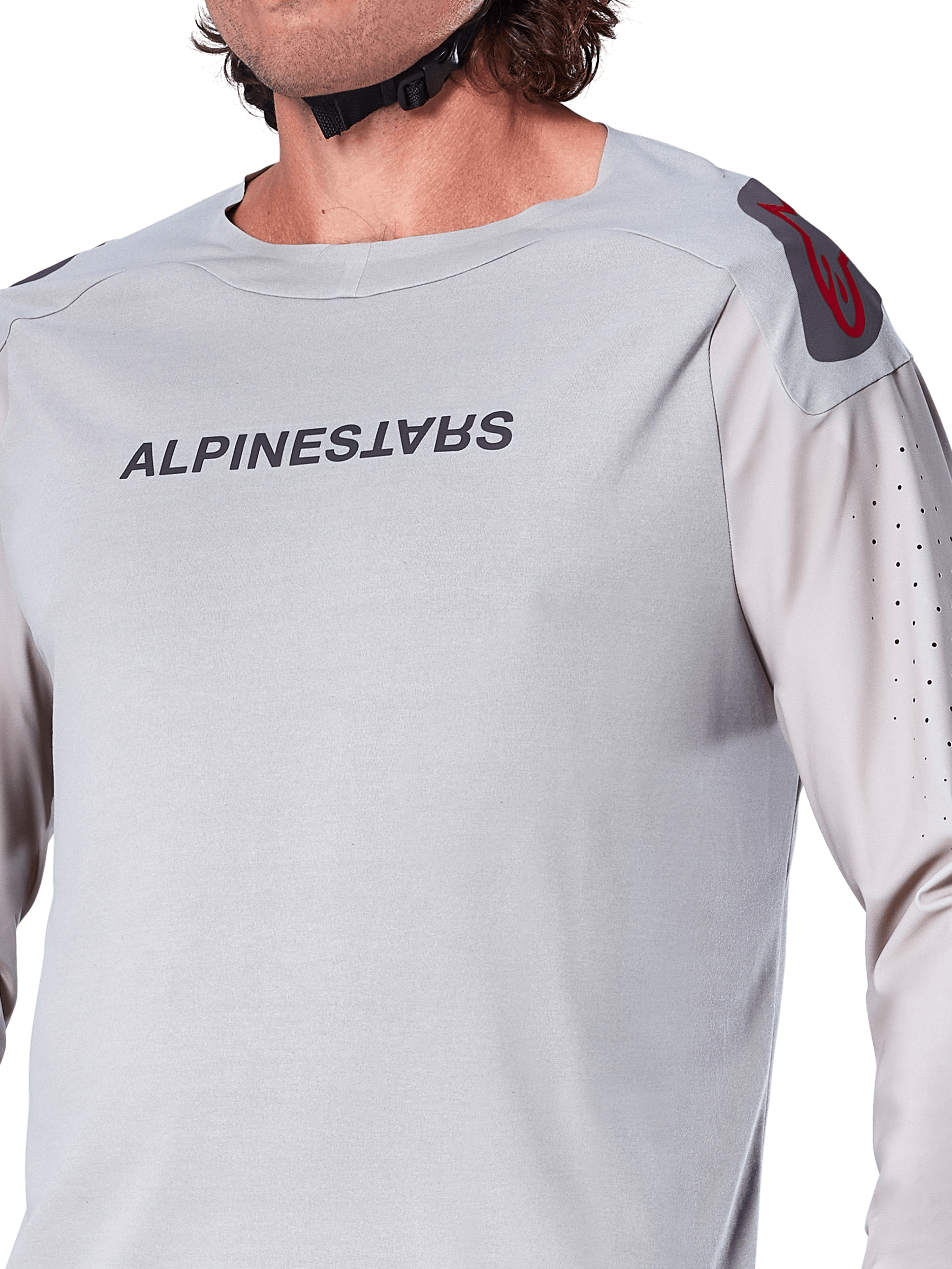 Gros plan sur le maillot à manches longues Alpinestars A-Aria Polartec Switch en gris clair, avec logo Alpinestars sur la poitrine, logo rouge sur l'épaule et manches perforées au laser pour la circulation de l'air, équipement de VTT haut de gamme