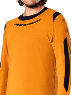 Alpinestars A-Dura Dri Wool Jersey met lange mouwen, Dark Gold, close-up van de zwarte ronde hals met logo en zwarte mesh ventilatiepanelen op de schouders en armen, hoogwaardige mountainbikekleding