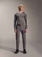 Alpinestars A-Dura Elite broek, donkergrijze mountainbikebroek, volledig vooraanzicht, gedragen met een bijpassende grijze performance jersey met lange mouwen en Alpinestars-logo, zwarte schoenen met rode accenten, sportieve fietsoutfit