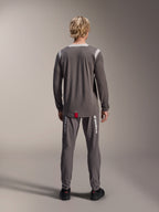Alpinestars A-Dura Dri Wool Jersey - Lange Mouwen, donkergrijs, achteraanzicht op model, met lichtgrijze mesh-panelen op de schouders en kraag, verlengde achterzoom met een klein rood merklabel, gedragen met bijpassende grijze fietsbroek