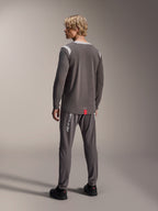 Alpinestars A-Dura Dri Wool Long Sleeve Jersey, donkergrijs met lichtgrijze mesh schouderpanelen, gecombineerd met bijpassende donkergrijze fietsbroek, achteraanzicht met de verlengde achterzoom, mountainbike-kleding