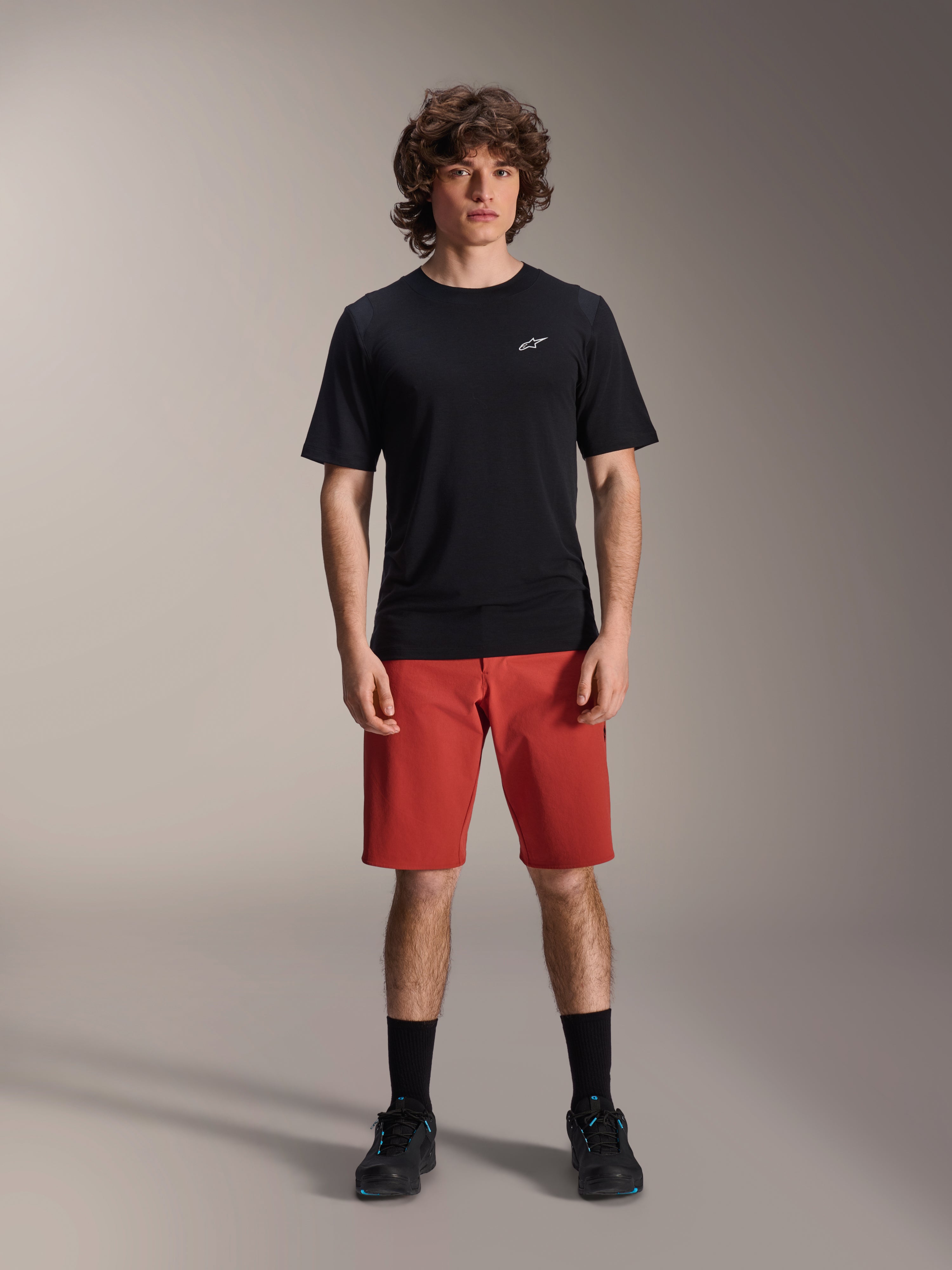 Alpinestars A-Dura Elite Shorts, MTB-Mountainbike-Shorts, Dunkelorange, getragen mit einem schwarzen kurzärmeligen Trikot und Radschuhen, Performance-Radsportbekleidung für das Mountainbiken