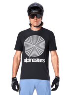 Maillot Alpinestars A-Dura Oscar, maillot de VTT à manches courtes, noir, avec un large graphique en spirale Oscar vintage blanc sur la poitrine, porté avec un casque de vélo noir, des lunettes de soleil, des gants noirs et un short bleu clair, équipement de cyclisme tout-terrain d'inspiration héritage