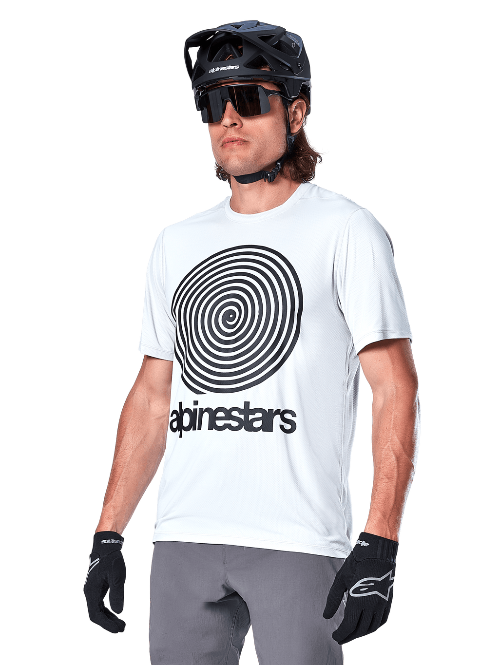 Maillot à manches courtes Alpinestars A-Dura Oscar, White Dove avec graphique spirale héritage noir et logo, porté avec casque de VTT et gants noirs, vêtement de performance sportif pour le VTT