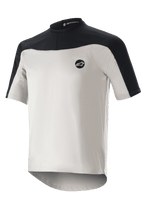 Alpinestars Drop Meta Jersey met korte mouwen, mountainbikeshirt, lichtgrijs en zwart, voorzien van een ademende mesh-constructie, zwarte schouderpas, ronde halslijn en een verlengde achterkant voor extra dekking
