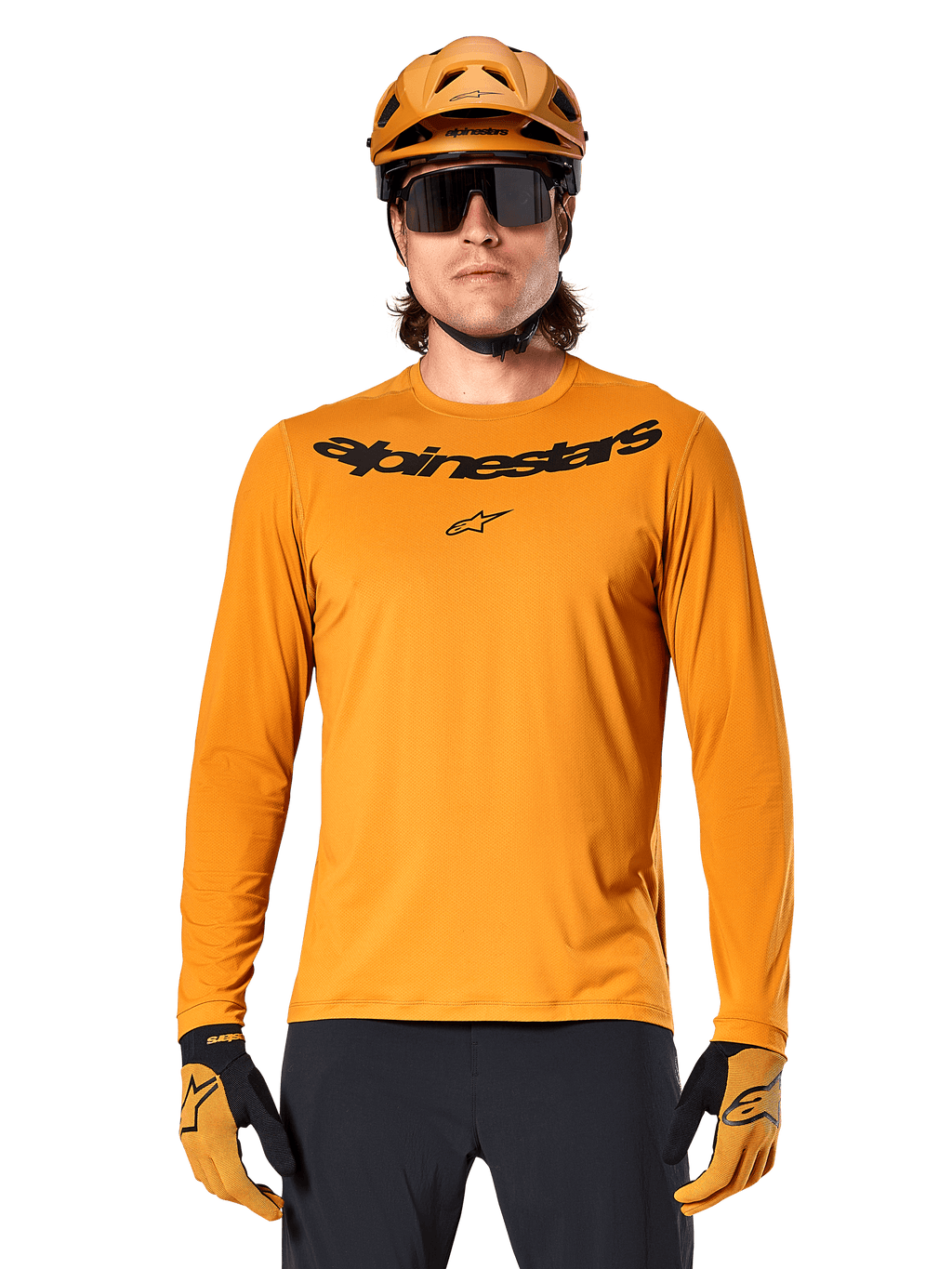 Alpinestars A-Dura Rocker Langarmtrikot in Dunkelgold, mit schwarzem Wortmarken-Logo auf der Brust, getragen mit einem passenden goldenen Helm und Handschuhen für Mountainbike-Performance.