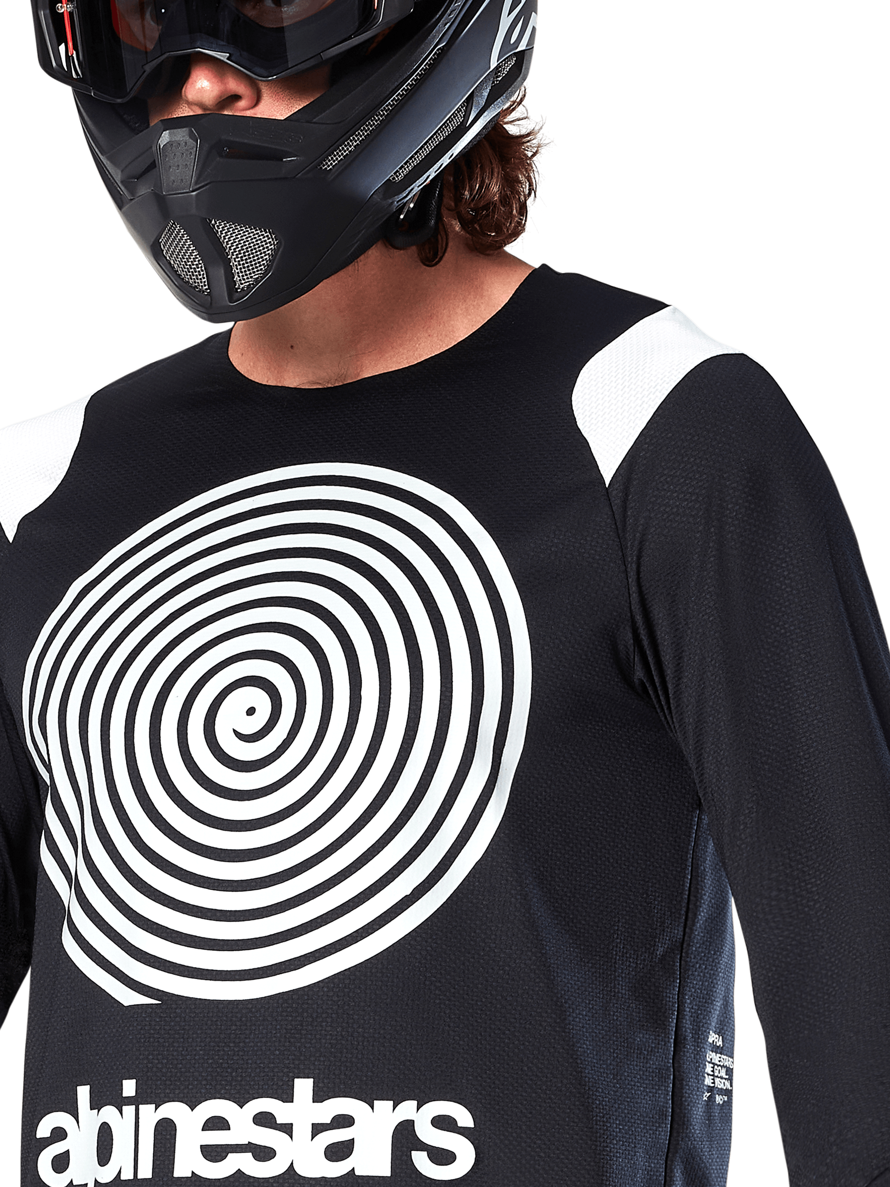 Maillot Alpinestars A-Supra Oscar, manches longues, noir, avec un grand graphique en spirale Oscar blanc sur la poitrine et le logo de la marque, porté par un pilote avec un casque intégral noir et un masque, vêtement de VTT haute performance pour la pratique du gravity