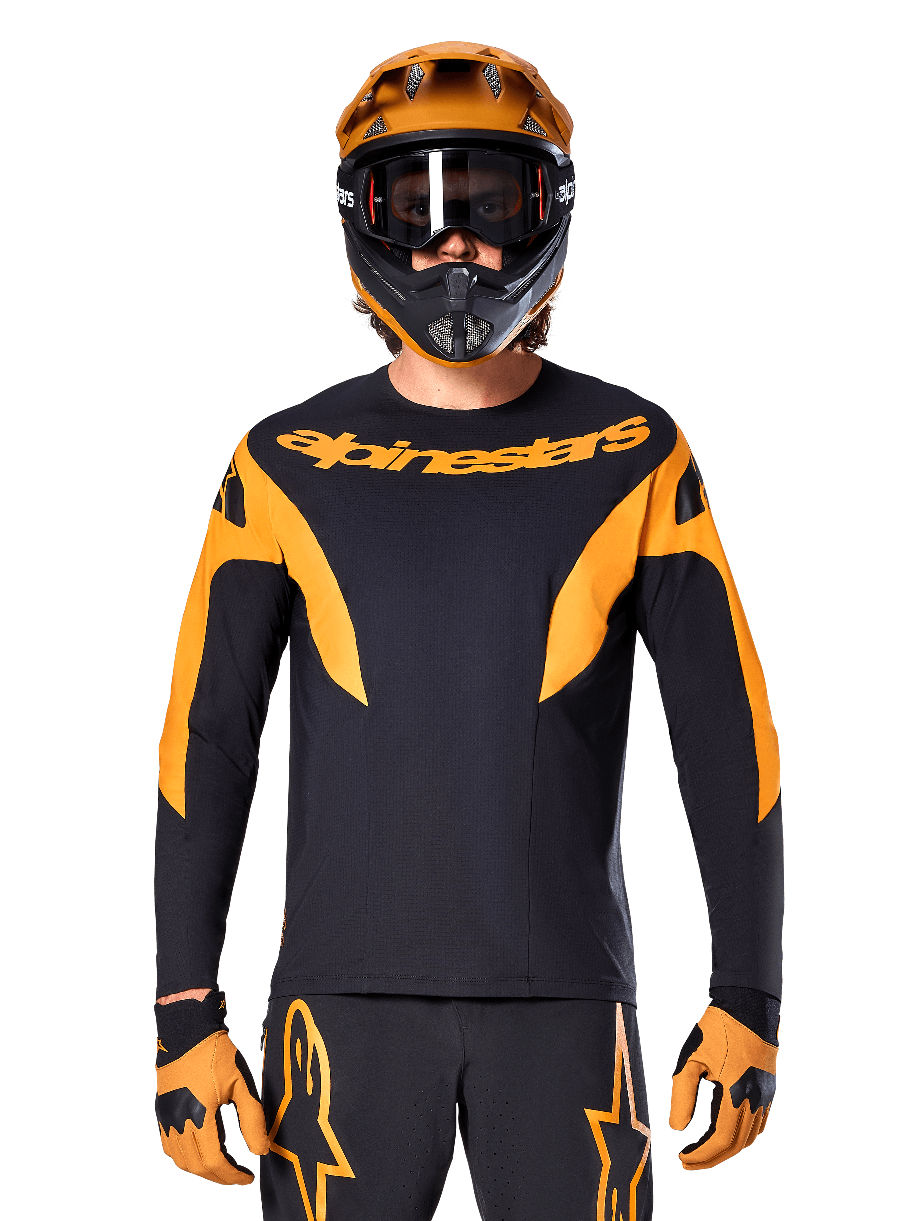 Pilote de VTT portant le maillot Alpinestars A-Supra Race à manches longues, noir avec graphismes orange et logo sur la poitrine, avec casque intégral orange assorti, masque noir et gants orange, tenue de course coordonnée pour la performance en VTT