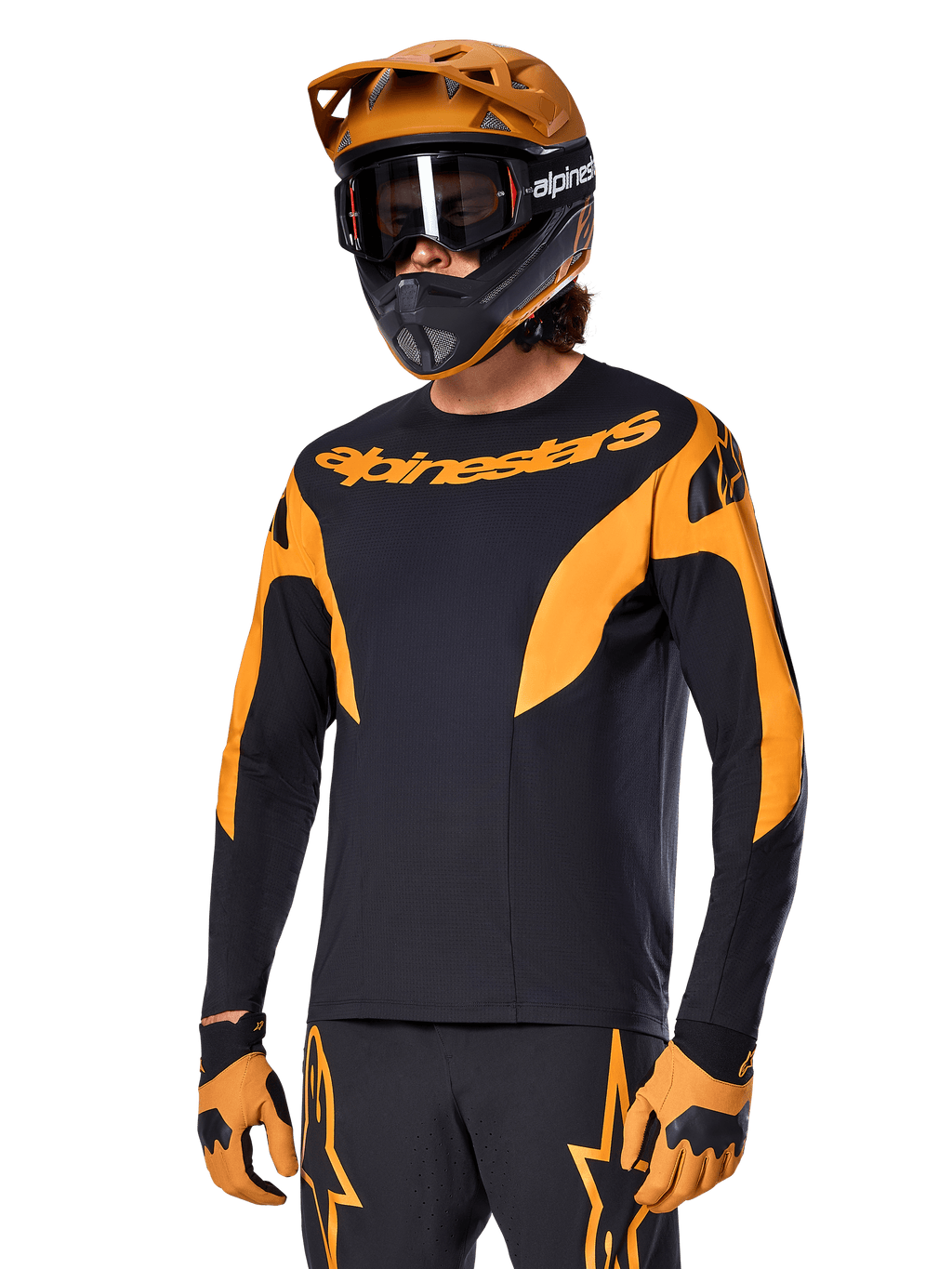 Alpinestars A-Supra Race Jersey à manches longues, maillot de VTT noir et orange, porté avec casque et gants assortis, avec logo Alpinestars sur la poitrine et accents stylisés sur les manches, coupe performance pour la course tout-terrain