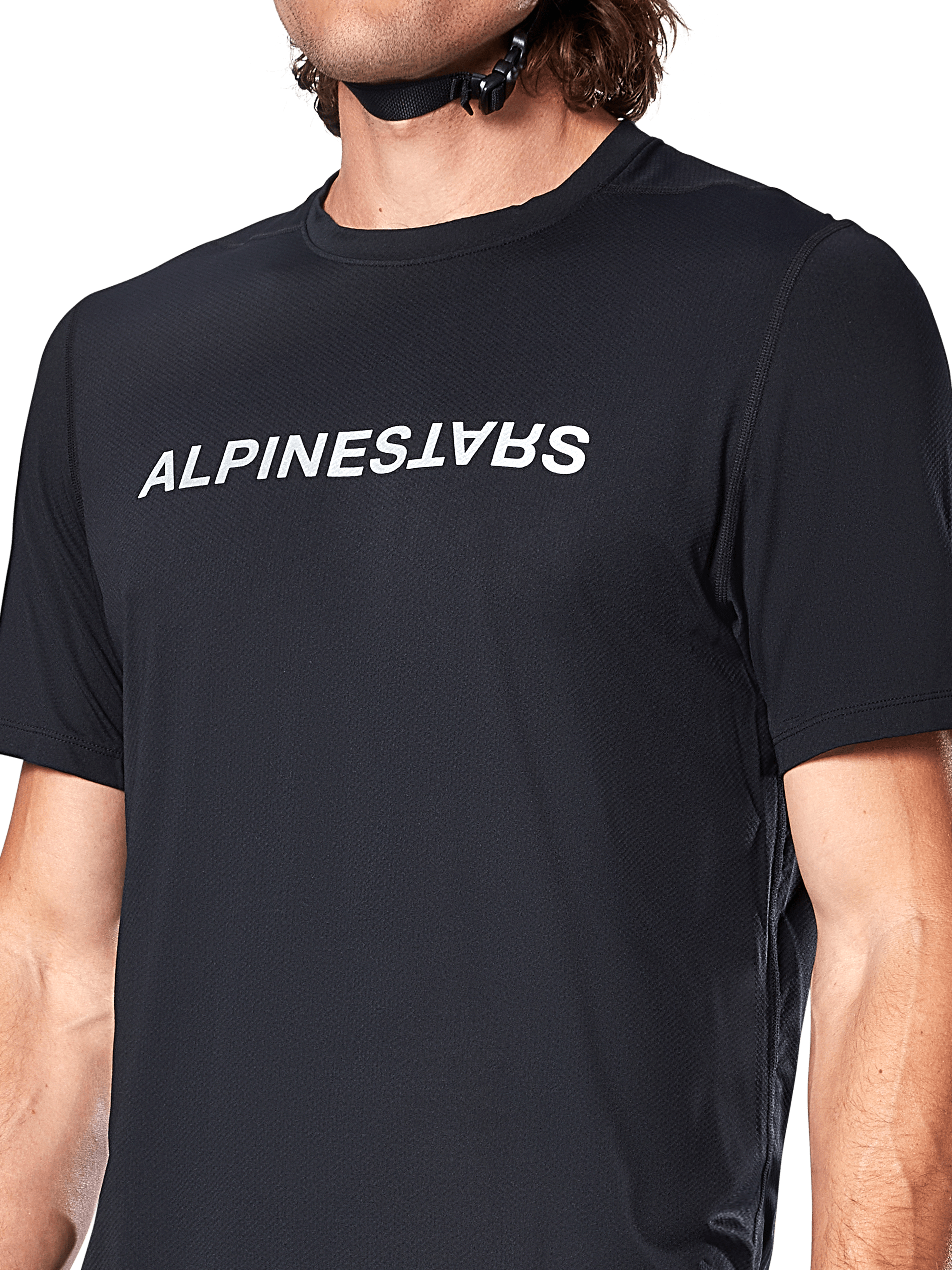 Alpinestars A-Dura Switch Jersey met korte mouwen, zwart, voorzien van een groot wit gezeefdrukt woordmerklogo op de borst, technische jacquardstof textuur, close-up vooraanzicht